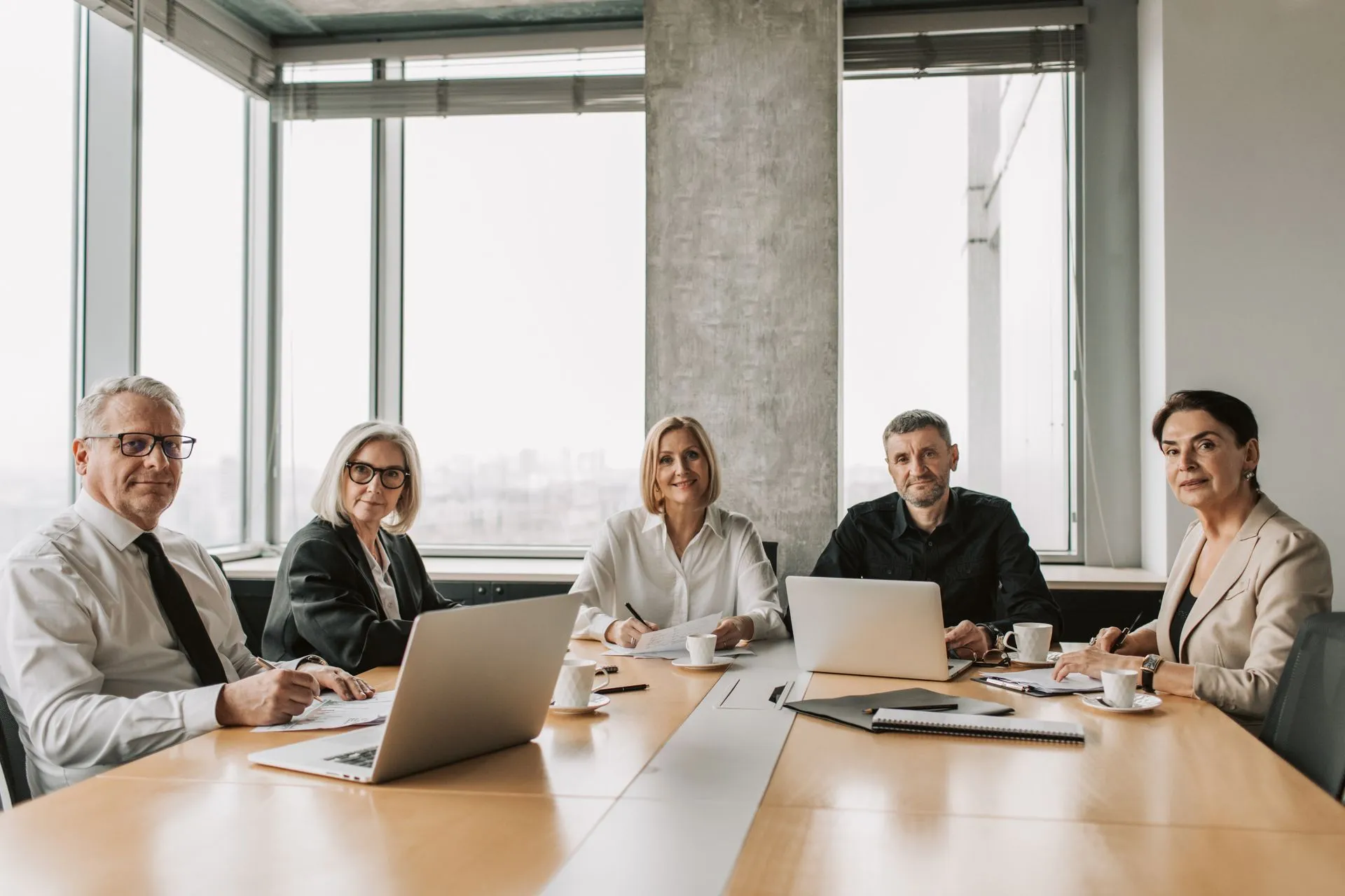 Une équipe de collaborateurs expérimentés réfléchit ensemble autour d’une table de réunion