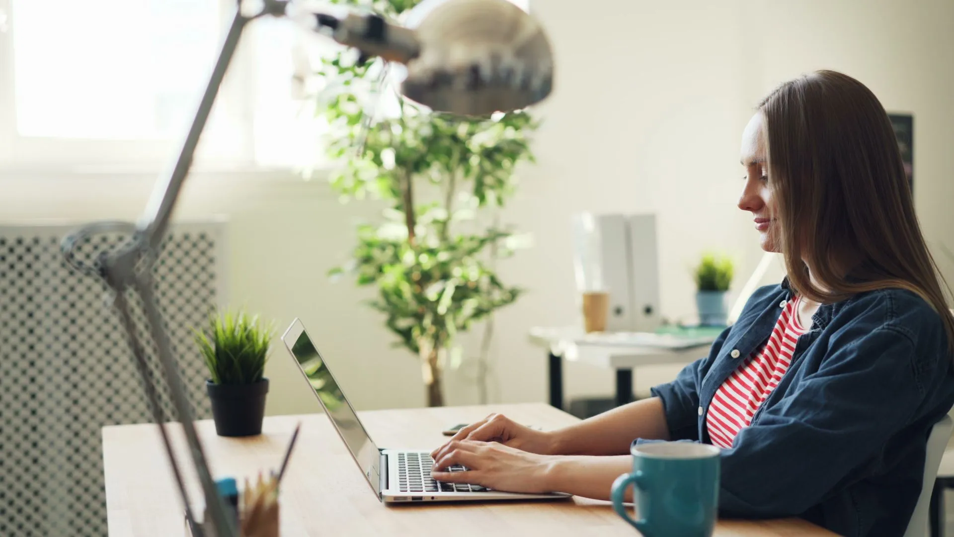Une femme travaille sur son ordinateur portable dans un bureau lumineux
